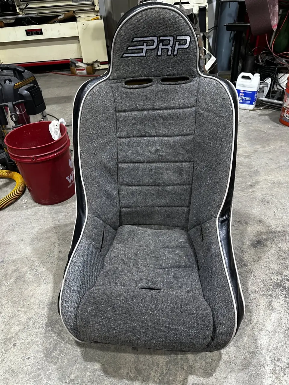 PRP bucket seat reupholstered in fresh gray fabric with black vinyl trim.